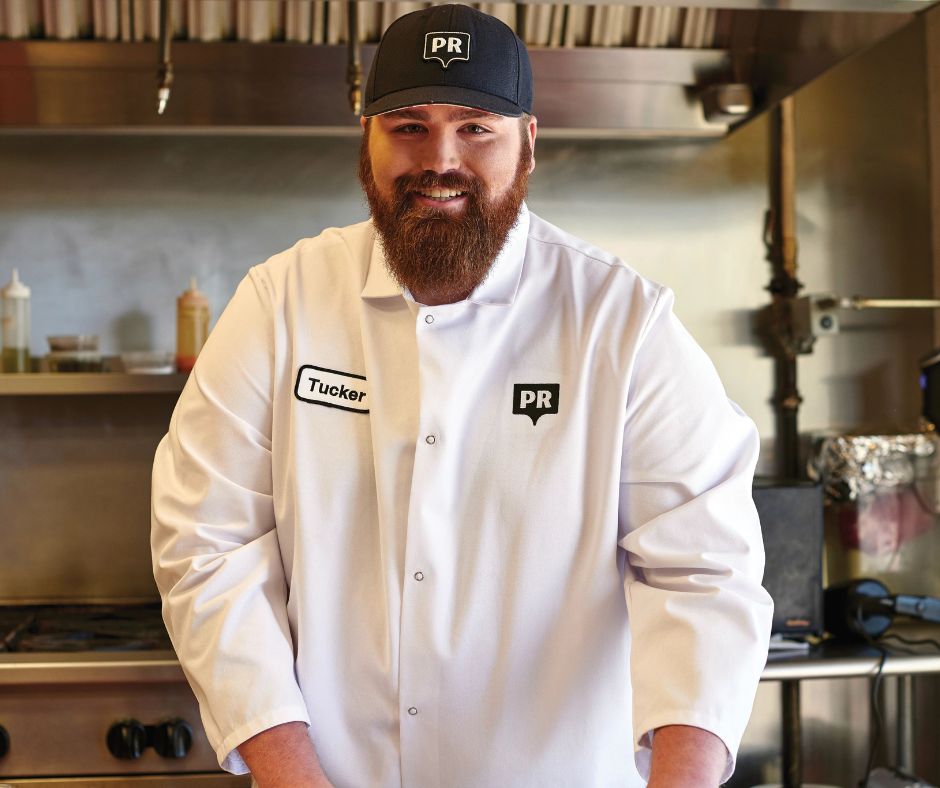 Chef wearing white pocketless chef coat in kitchen