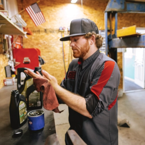 Mechanic wiping hands of grease with red towel